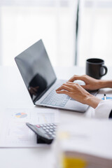 Asian Business woman using calculator and laptop for doing math finance on an office desk, tax, report, accounting, statistics, and analytical research concept