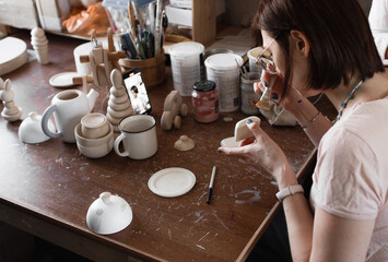 the girl shoots a video about the process of making wooden toys in the workshop