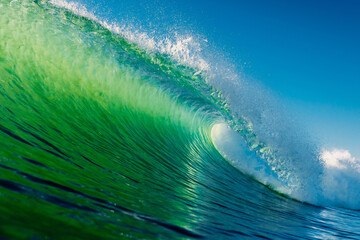 Ideal barrel wave with green tones in ocean. Swell waves for surfing