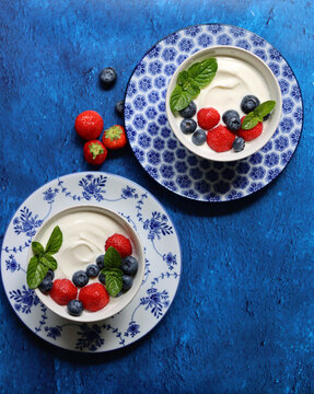 Non Dairy Yogurt With Organic Strawberry, Blueberry, Cherry And Mint Leaves. Healthy Vegetarian Breakfast On A Table. Top View Photo Of Fresh Summer Fruit. 