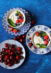 Vivid still life with summer berries on a table. Textured background with copy space. Fresh organic fruit on a table. Eating healthy concept. 