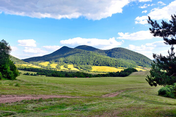 Beautiful summer evening landscape in the mountains with green meadows and forested hills. View of Mountain Busov (1002 msl) in
 Low Beskids. (Beskid Niski). - obrazy, fototapety, plakaty