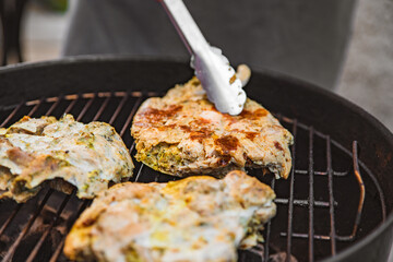 young man chef grilling chicken meat outdoor