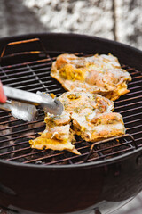 young man chef grilling chicken meat outdoor