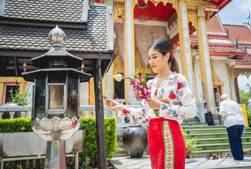 Beautiful Asian girl at big Buddhist temple dressed in traditional costume