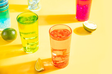 Summer alcoholic cocktails in colorful glasses on yellow background. Summer sea ocean vacation and travel concept