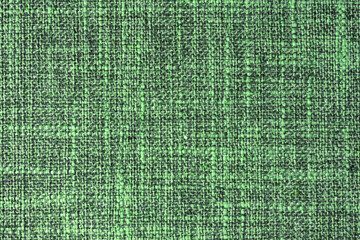 Close-up texture of natural green coarse weave fabric or cloth. Fabric texture of natural cotton or linen textile material. Blue canvas background. Decorative fabric for upholstery, furniture, walls