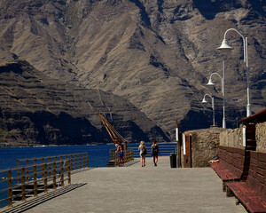 Old fishing dock in foreground and mountain slopes in the background, coast of Agaete, north of...