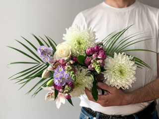 Man holding bouquet of fresh beautiful spring flowers charming flowers as a gift for mother, father, girlfriend or wife. Present or gift. postcard concept idea