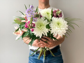Man holding bouquet of fresh beautiful spring flowers charming flowers as a gift for mother,...