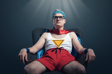 Funny superhero sitting on an armchair