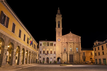 Fototapeta na wymiar Montevarchi, Arezzo, Tuscany, Italy: night view of the main square Piazza Varchi with the ancient church Collegiata di San Lorenzo, the medieval building Palazzo del Podesta and the Town Hall