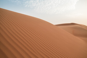 Fototapeta na wymiar Close-up of sand dunes from the side of a desert hill in Al Wathab, Abu Dhabi, United Arab Emirates.