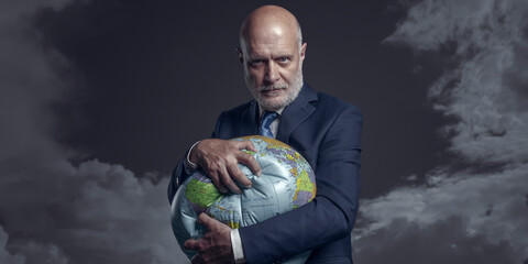 Greedy corporate businessman crushing and exploiting earth - obrazy, fototapety, plakaty