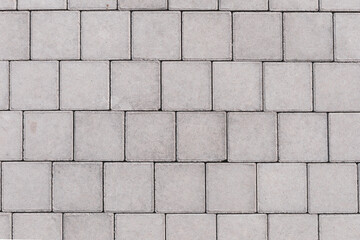 Gray brick stone on street. Top view. pavement texture with concrete bricks
