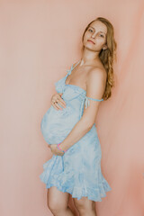 portrait of a person
Beautiful pregnant woman holding her belly and relaxing with cup of morning coffee in bed during pregnancy. Young mother waiting for baby. Minimalist modern style photography.