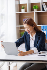 Fototapeta na wymiar Happy excited young Asian woman with a laptop at home sitting in-home office, Emotional girl feeling glad and happy 