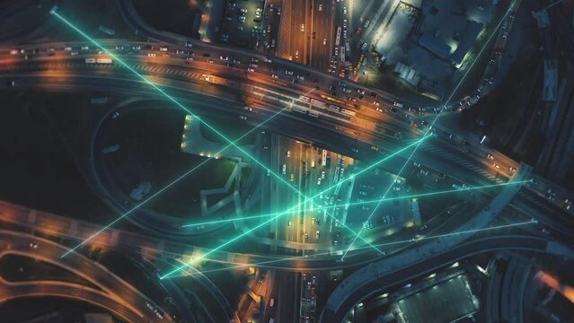 Top down panning shot of busy multilane and multilevel highway interchange at night. Visual effects representing direct communication between cars. Istanbul, Turkiye