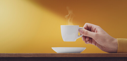 Hand holding a cup of coffee