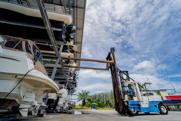 Forklift loading speedboats in a garage system in the marina