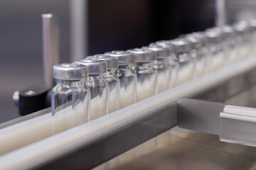 Conveyor belt with empty medical injection glass vials - pharmaceutical automatic production line....