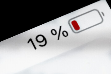 Low level of smartphone charged pixel battery level indicator - nineteen, 19 percent: close up...