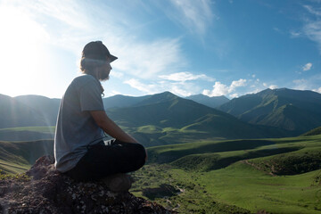 Young man preforms yoga in mountains