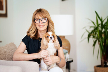 Attractive woman sitting with her dog at home and relaxing together