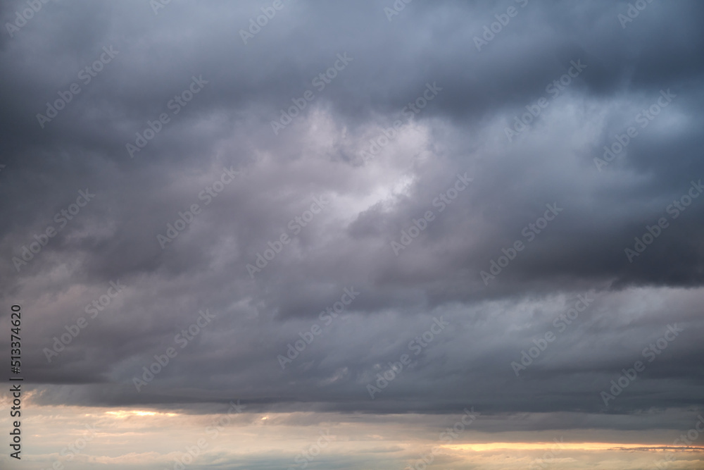 Wall mural Dark rain clouds in the evening sky. Dramatic sky with an coming cloudy cyclone of bad weather