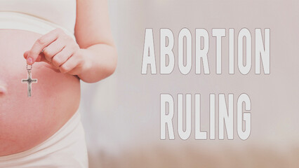 Text about the rules of abortion and chained hands of a pregnant woman, home living room
