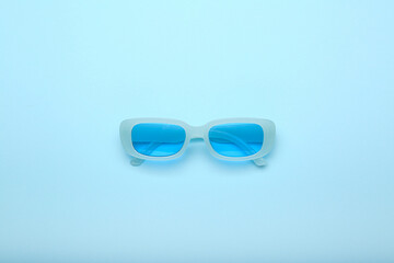 blue sunglasses on a blue background, top view