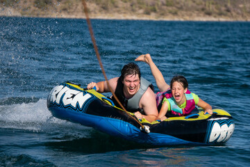 Father and daughter tubing on the water