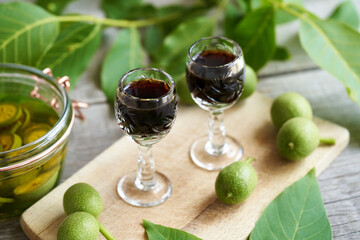Two glasses of homemade nut liqueur made from unripe walnuts