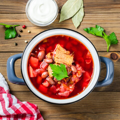 Traditional beetroot soup borscht in pot on dark wooden background. Top view, copy space.