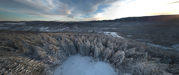 Panoramic view of the top of snowy mountains. Winter snowy mountain forest aerial view.