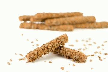 Integral sticks with sunflower seeds isolated on bright background. Selective focus.