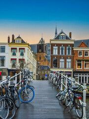 Bicycles on a wooden bridge with beautiful dutch houses on a canal in the in Leiden, Netherlands