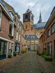Fototapeta na wymiar Cobblestone street with beautiful Dutch houses on either side in Leiden, Netherlands