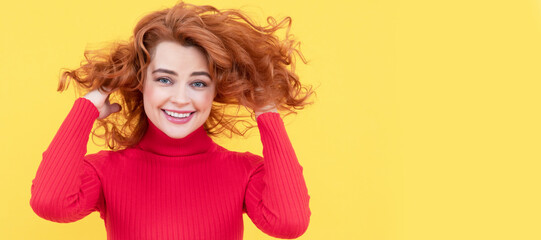 happy redhead woman with windy curly hair on yellow background, haircare. Woman portrait, isolated header banner with copy space.