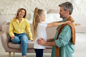 Obraz premium Daughter Hugging Dad While Mom Sitting On Sofa At Home