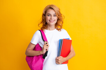 Cute student woman with backpack holds some documents and books over yellow background. Portrait of smiling young woman student in shirt backpack hold notebooks. Education in high school university