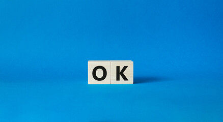 Ok symbol. Concept word Ok on wooden cubes. Beautiful blue background. Business and Ok concept. Copy space.