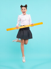Teenager child school girl holding measure for geometry lesson. Measuring height. Measuring equipment. Kid student study math. Happy positive and smiling schoolgirl.
