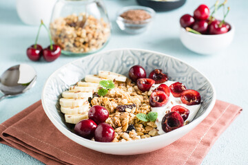 Granola with cherry, banana and flax seeds in a bowl on the table. Homemade breakfast