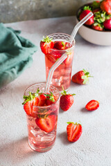 Two glasses with a strawberry cocktail and a bowl of berries. Homemade drinks. Vertical view