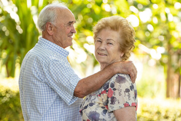 senior older couple cuddling outdoors
