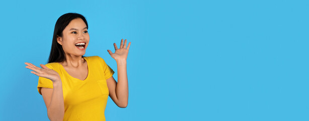 Happy surprised young japanese woman with down syndrome looking at empty space and gesturing with...