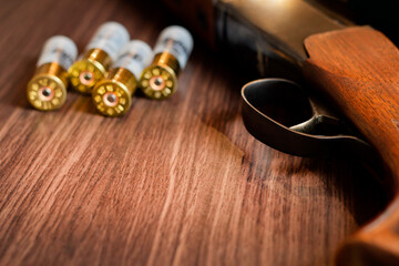 Shotgun with bullets on a wooden background.