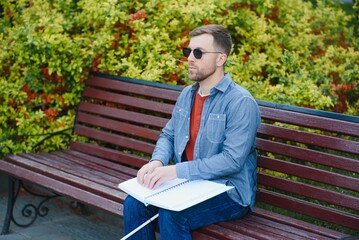 Fototapeta premium Blind man reading book on bench in park