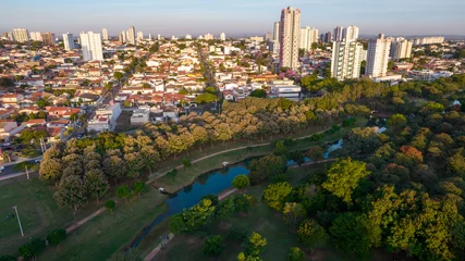 Fototapeten Indaiatuba Ecological Park. Beautiful park in the city center, with trees and houses. Aerial view © Pedro